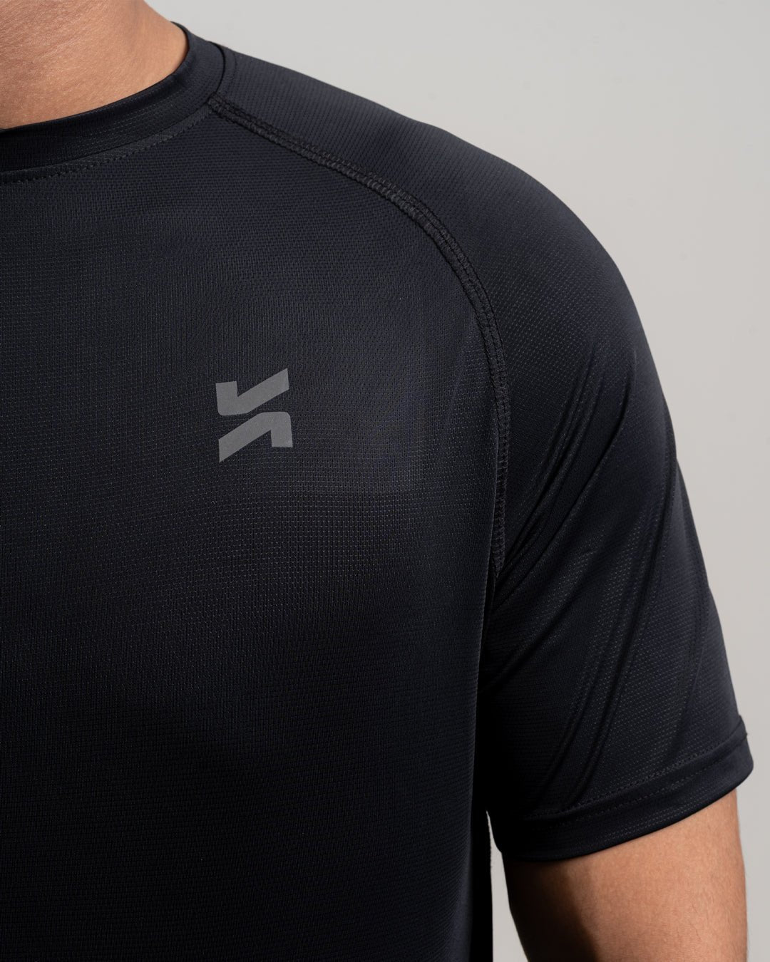 Close-up of performance raglan T-shirt for men in black by KYRIX