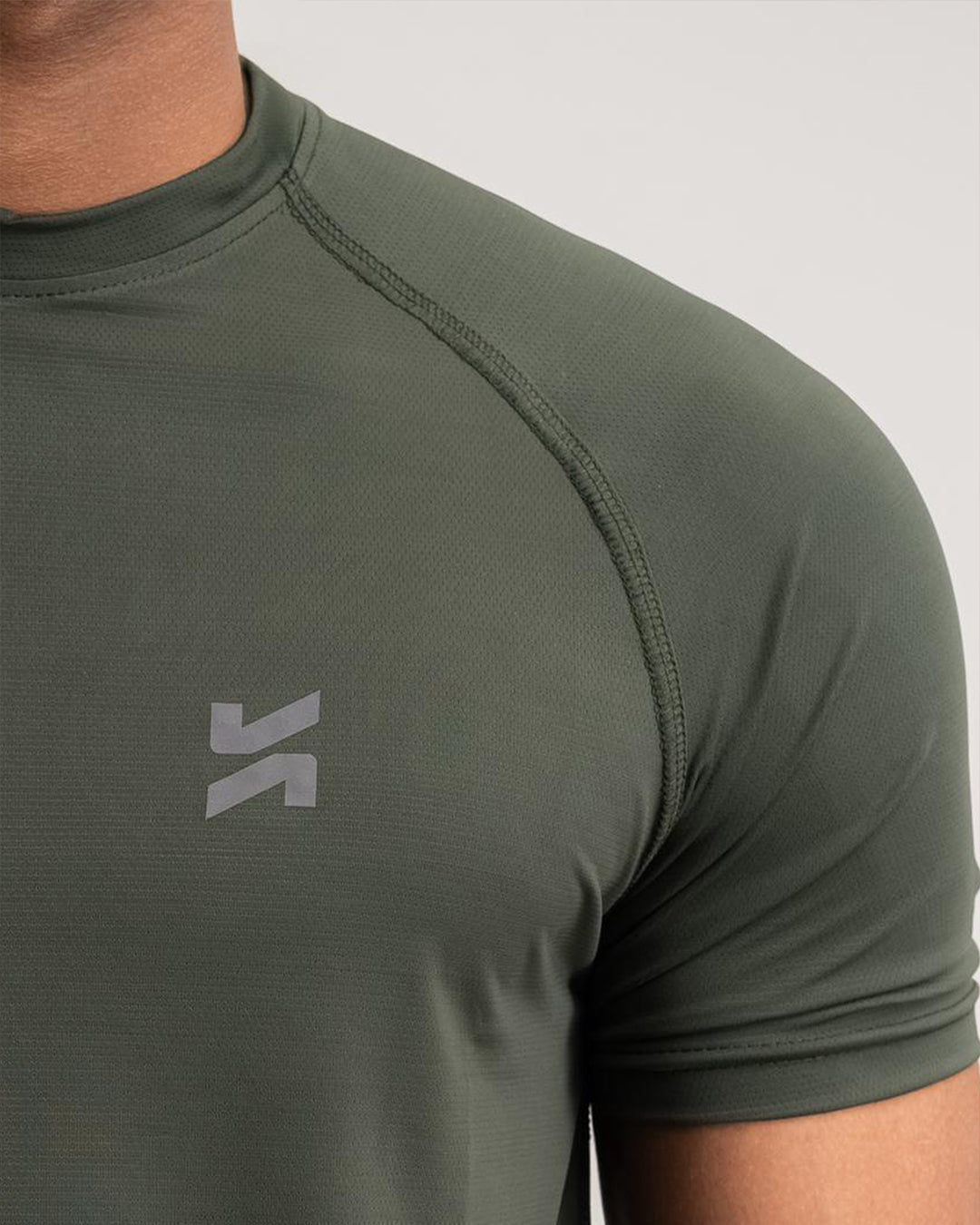 Close-up of lightweight raglan T-shirt logo in olive green by KYRIX
